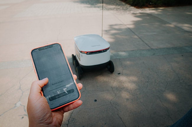 person with phone controlling robot