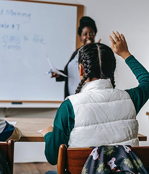 Teacher calling on a student who has her hand raised