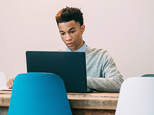 Young man at a laptop in a conference room