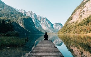 person meditating on a pier