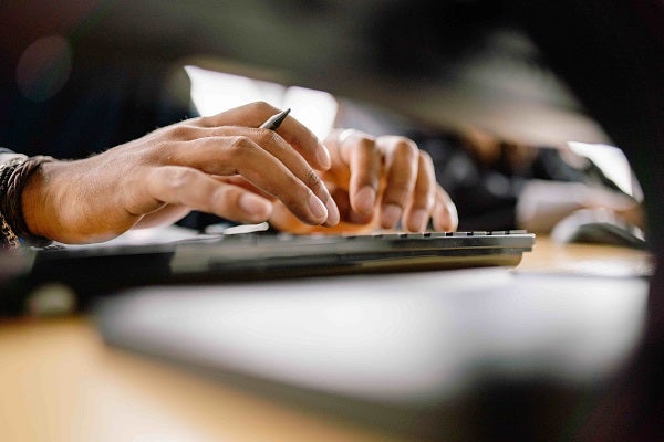 close up images of hands typing on a keyboard