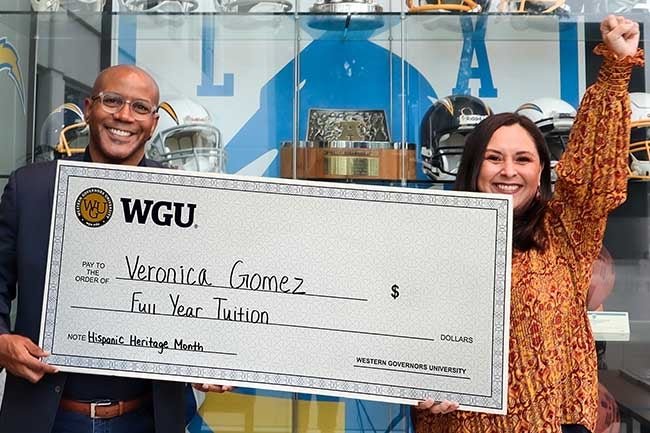 Man and woman holding large check.