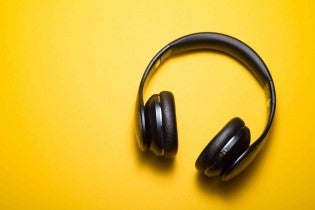 Black headphones resting on a yellow background