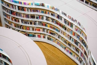 a room full of curved shelves with books