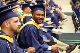 person in a blue cap and gown at WGU commencement