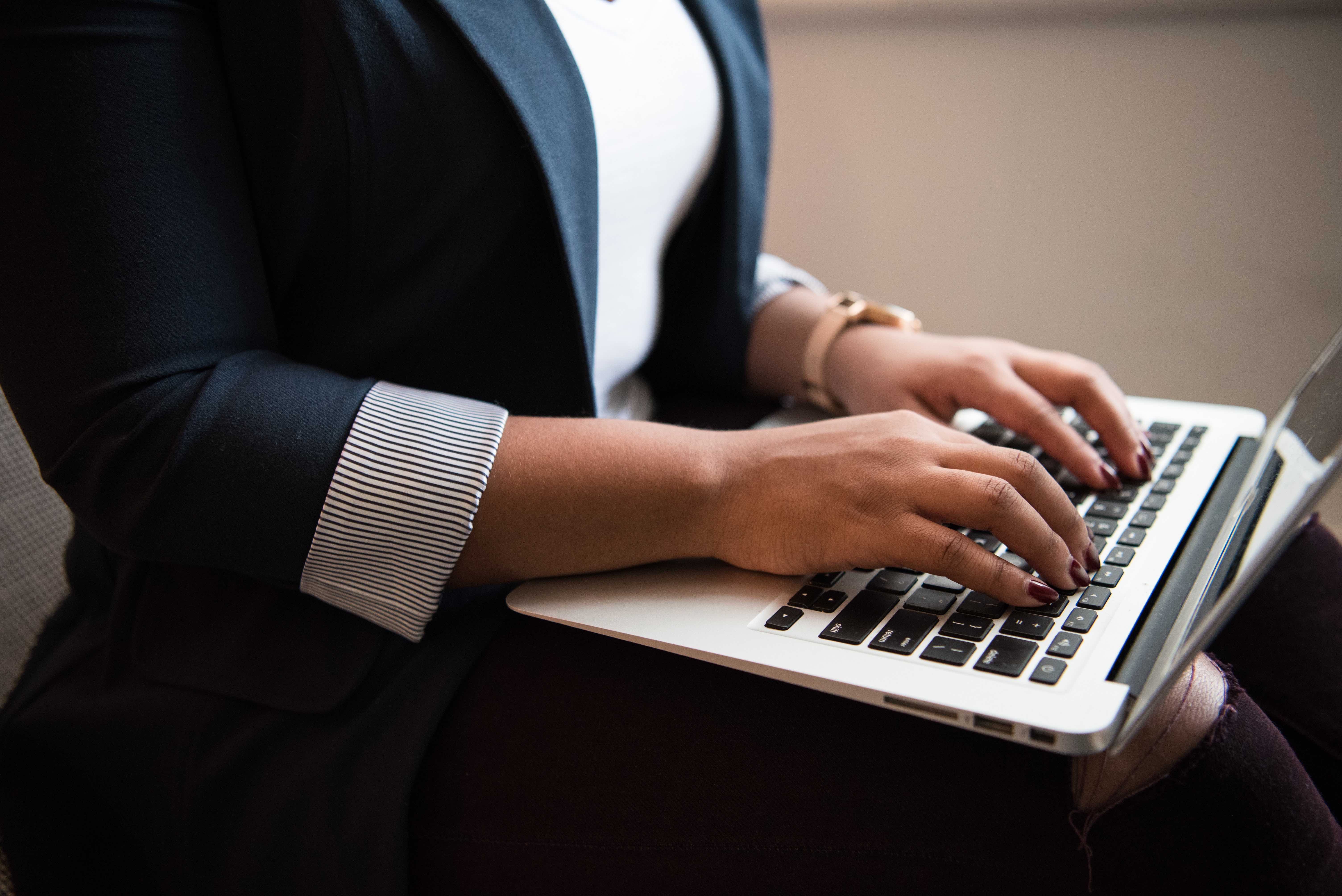 Close up of a person typing on a laptop
