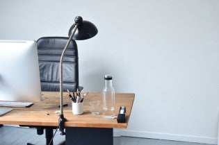 a desk with a computer and an empty chair