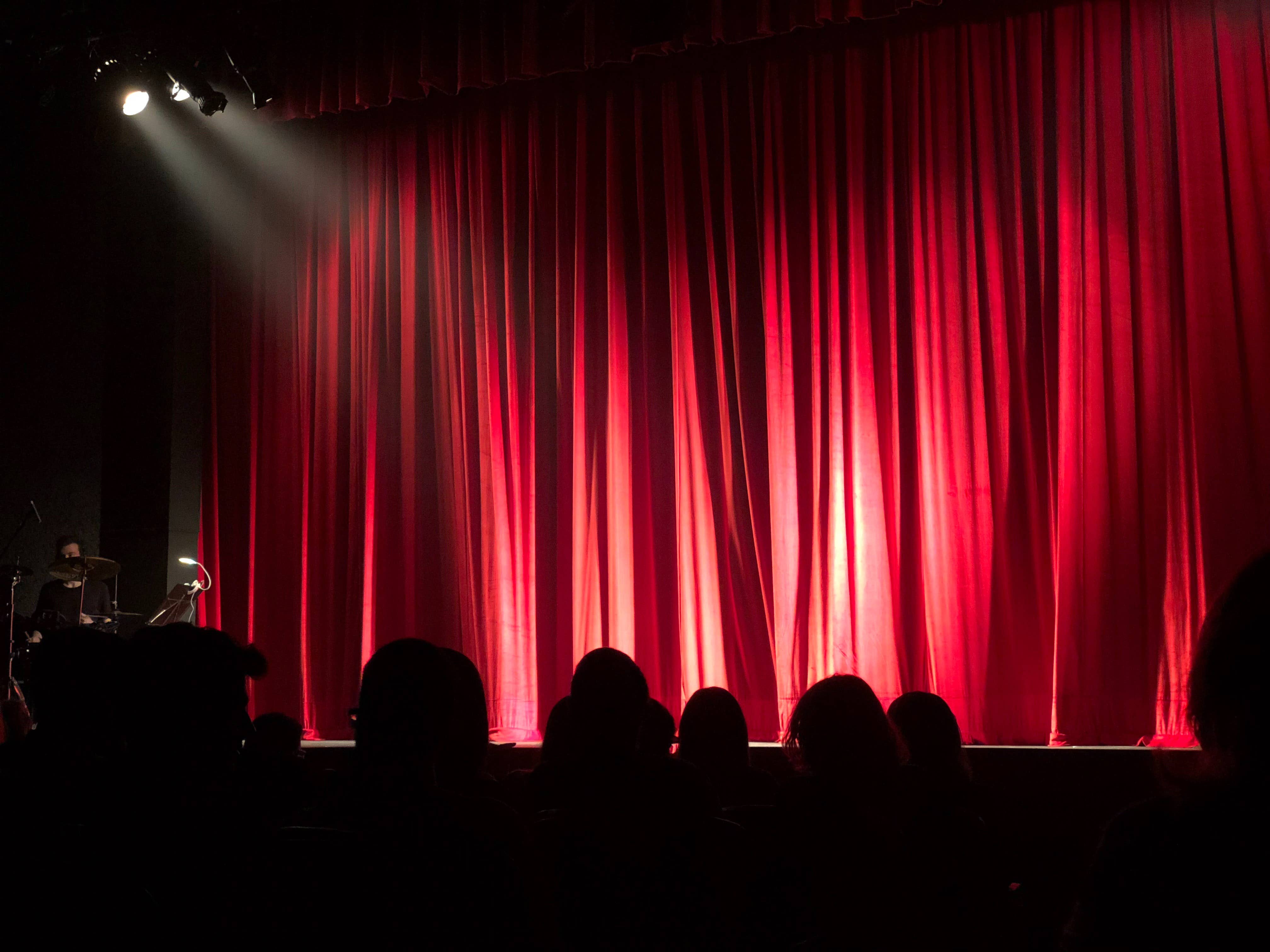 an empty stage with red curtain and light shining