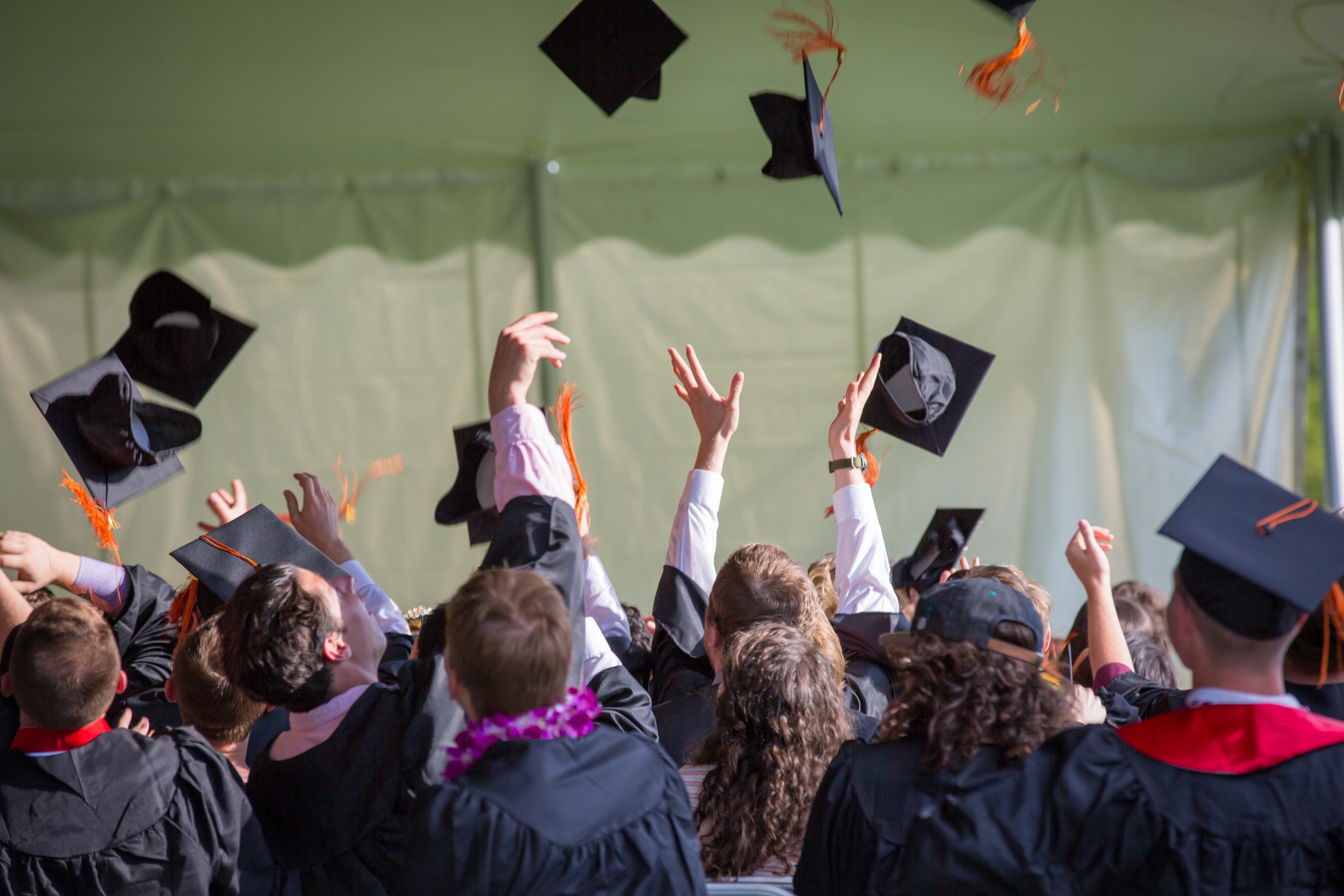 a group of students throwing graduation caps