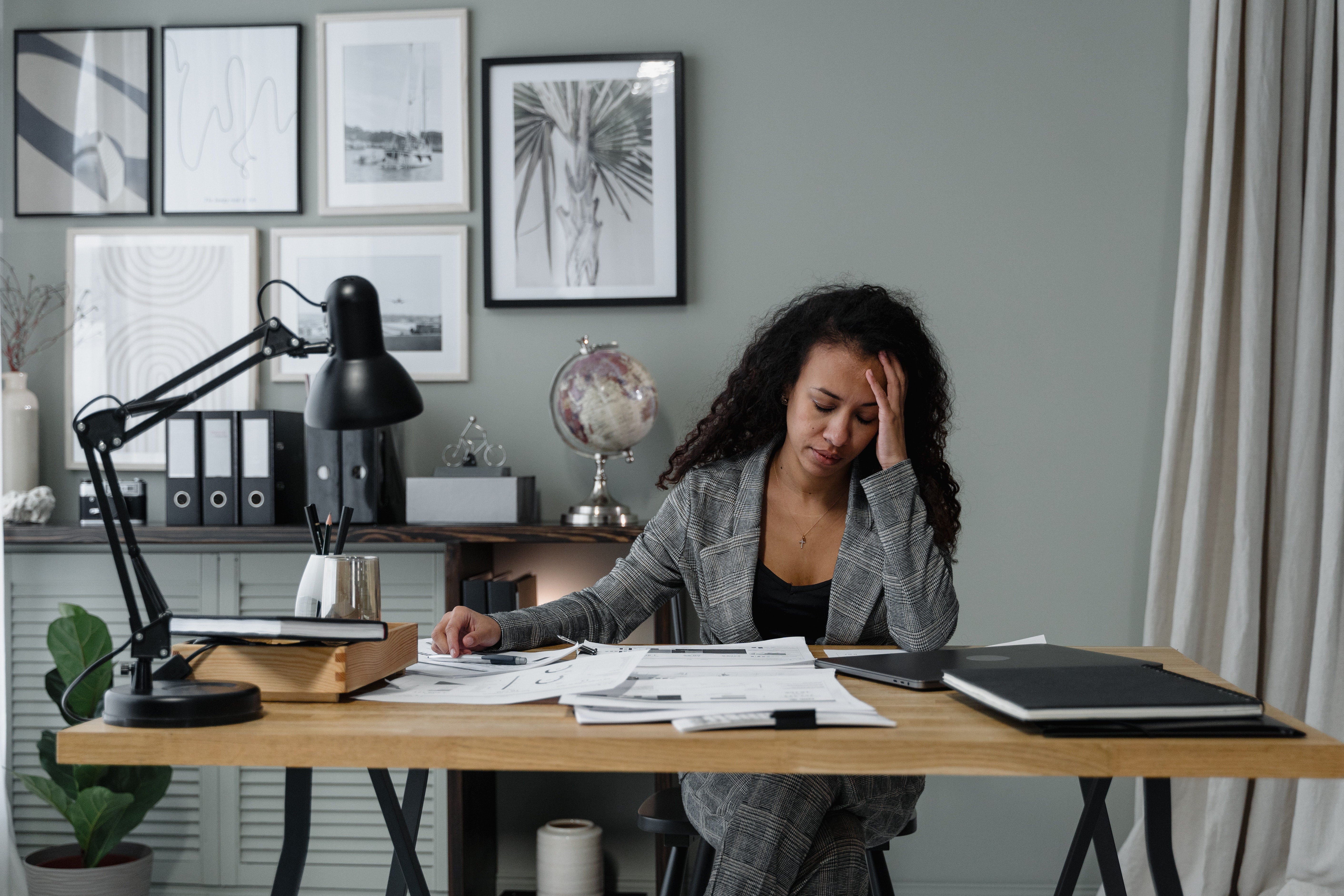 person sitting at a desk with their head in their hand