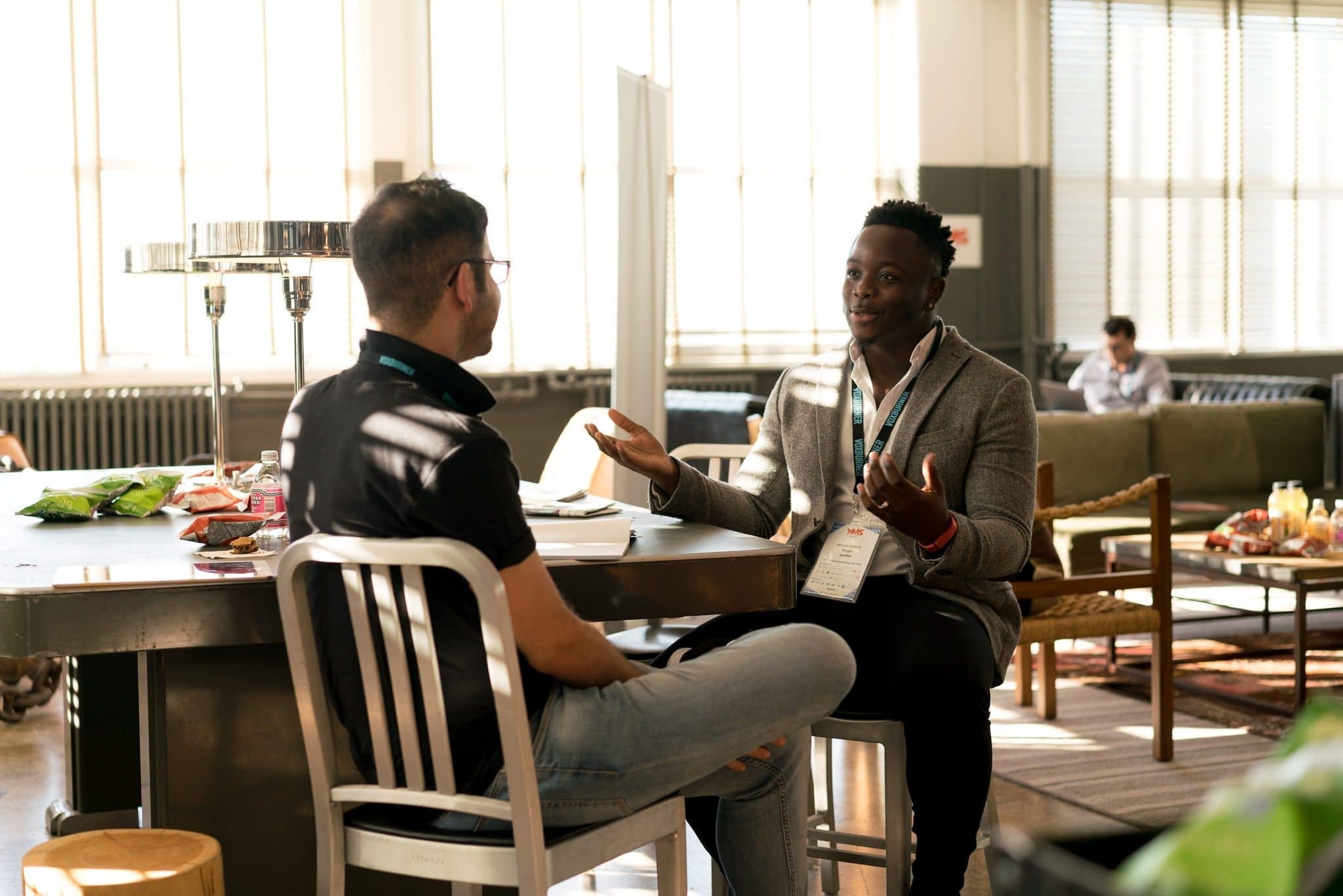two people sitting at a desk talking
