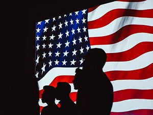 People standing in front of flag