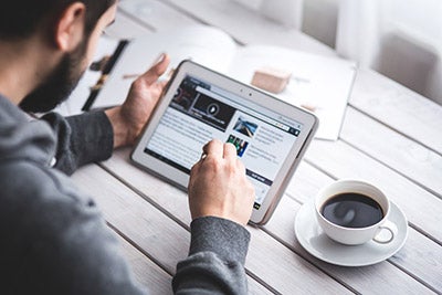 Man on tablet with coffee