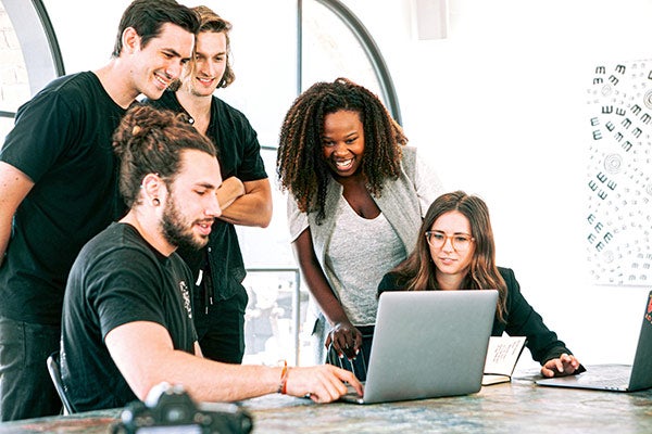 Colleagues collaborating on a project over a laptop