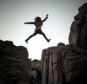 Person leaping over a chasm