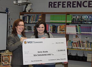 Emily Stutts with scholarship check