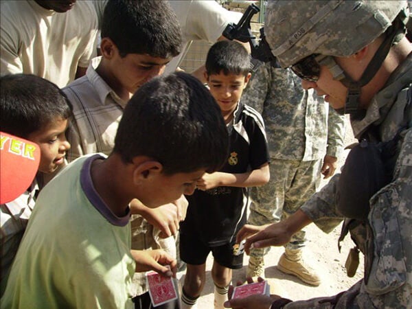 Jason Sims performs a card trick for a group of young boys