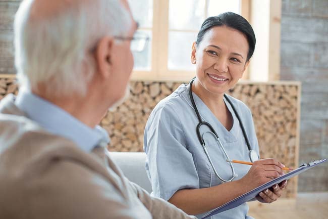 female nurse charting notes for a male patient