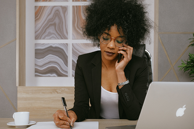 Woman writing on paper in business setting