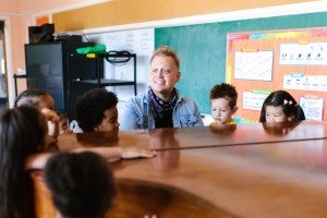 man teaching music to young children