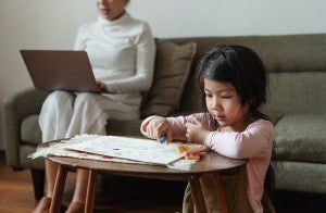 mom studying with child playing nearby