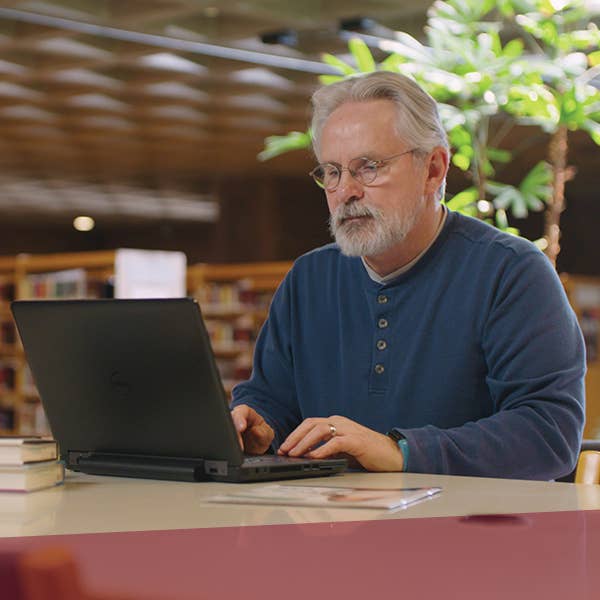 Man working at laptop in a library