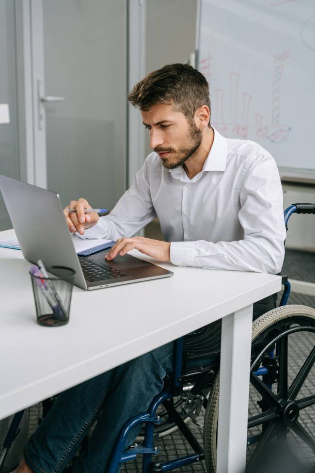 Man in a wheelchair working on a laptop