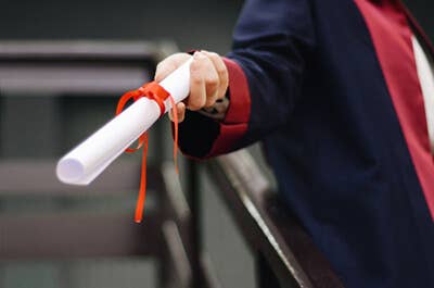 View of a graduate's hand holding a diploma