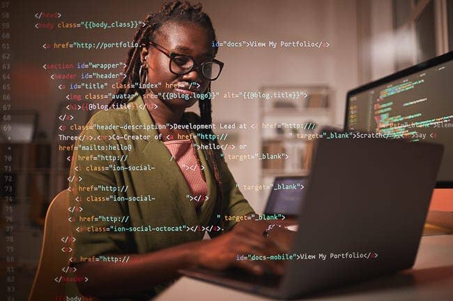 Woman in green shirt typing at computer with lines of code superimposed on the image
