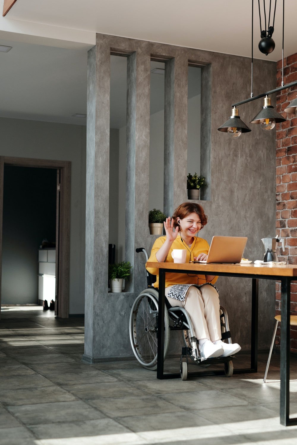 Women in a meeting on her laptop sitting in a wheel chair 