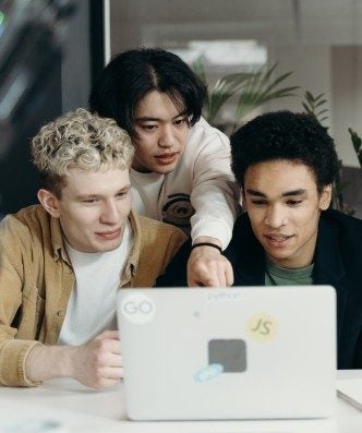Group of students meeting together looking at laptop