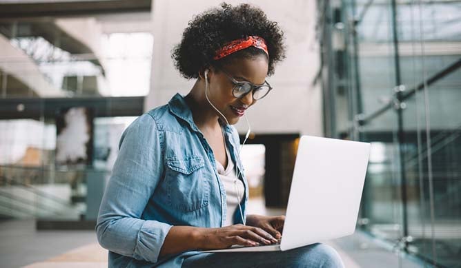 women working on laptop and listening to music