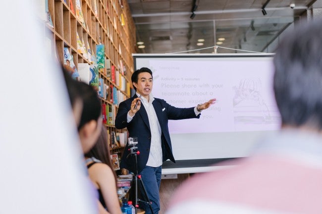 man leading a meeting in front of a white board