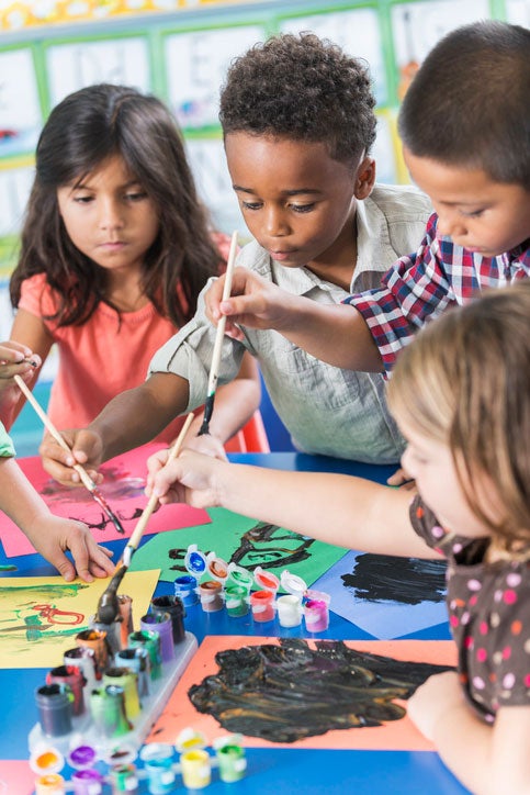 Elementary school kids painting in an art class