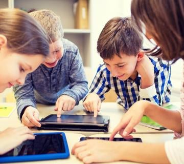 Group of children playing on digital tablets