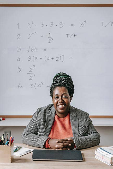 Math teacher sitting behind desk in a High School Math class
