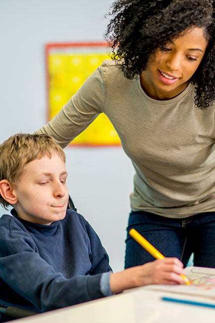 Special education teacher works with a boy with developmental challenges