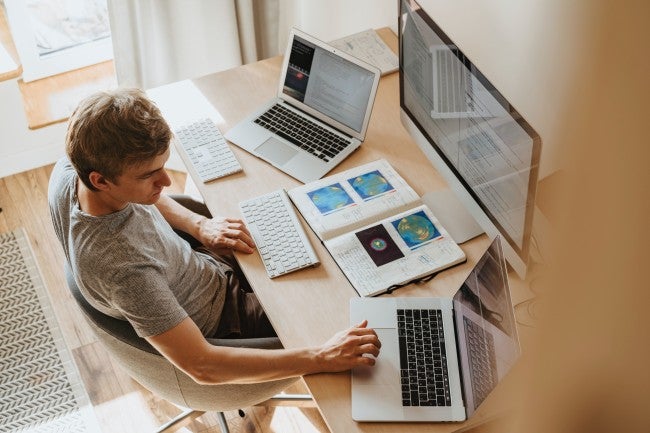 Student with three laptops doing online school