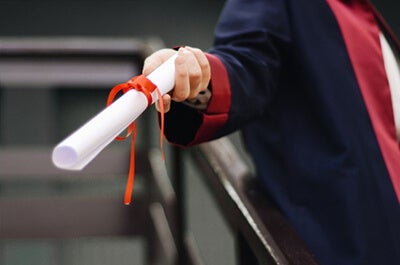 View of a graduate's hand holding a diploma