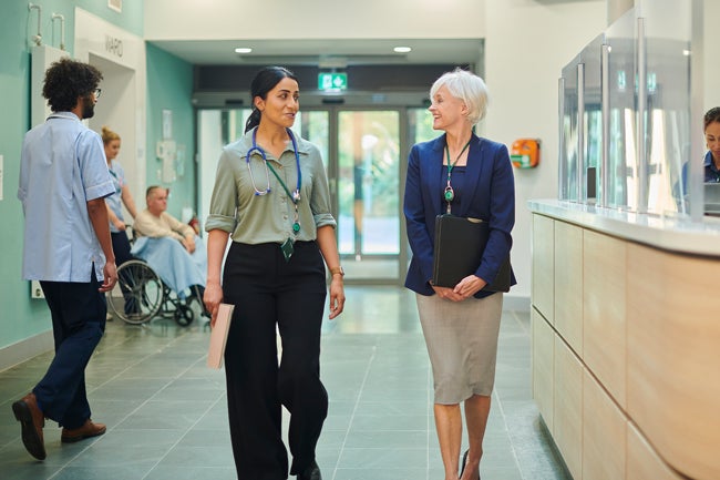 Healthcare worker and administrator walking in a hospital