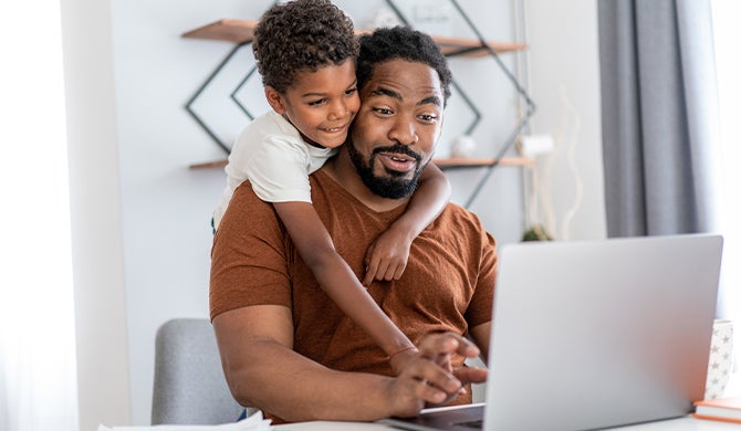 Father and son looking at laptop together at home