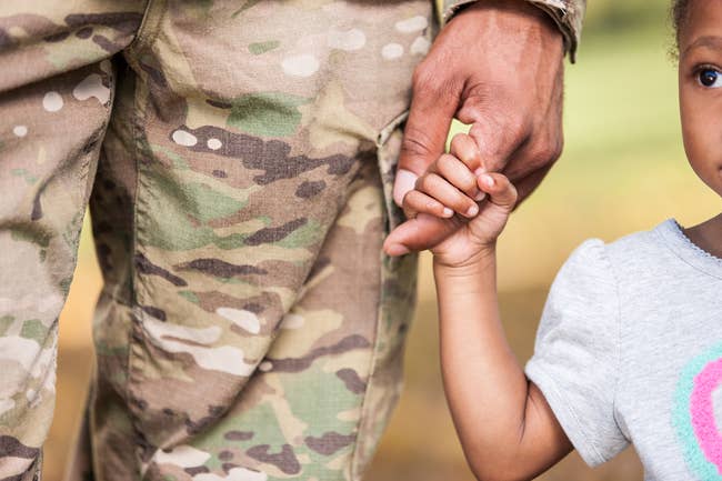 Military dad holding hand with daughter