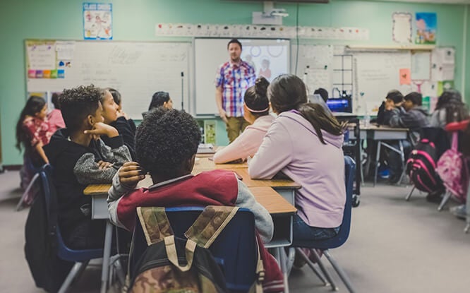 Male teacher in front of a classroom