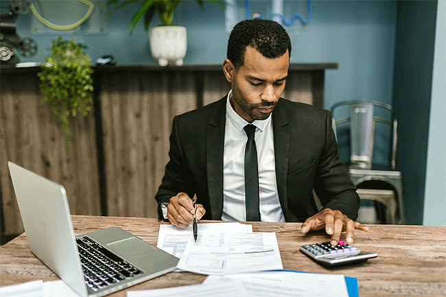 Man doing auditing with a calculator and papers