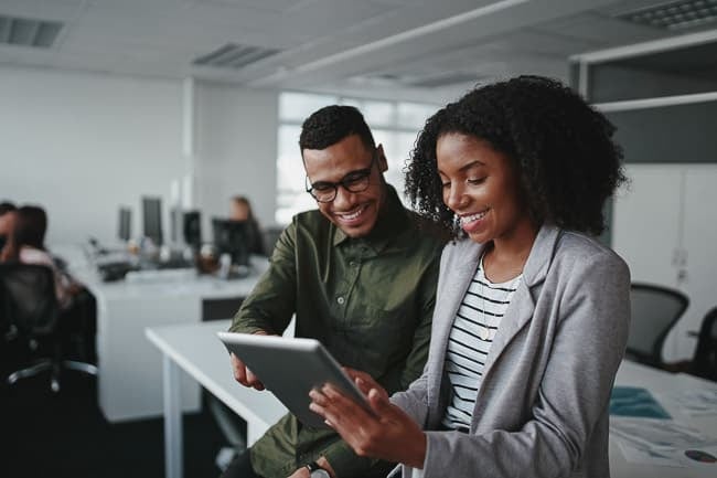 Man and women talking while looking at an ipad