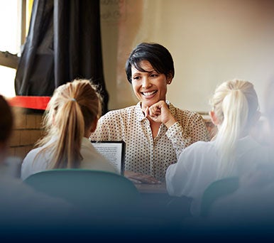 A female teacher works with young students
