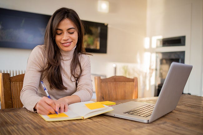 Happy young woman is enjoying working from home