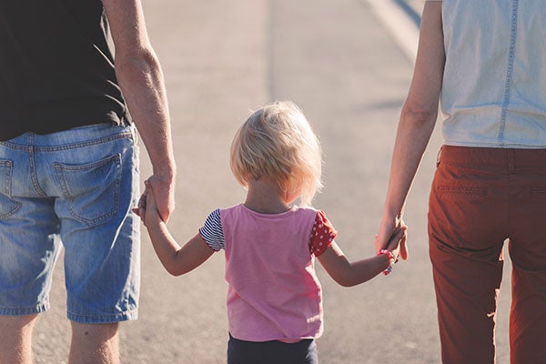 Family holding little child's hand