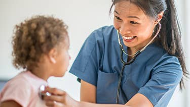 Pediatric nurse listening to a patient's heartbeat