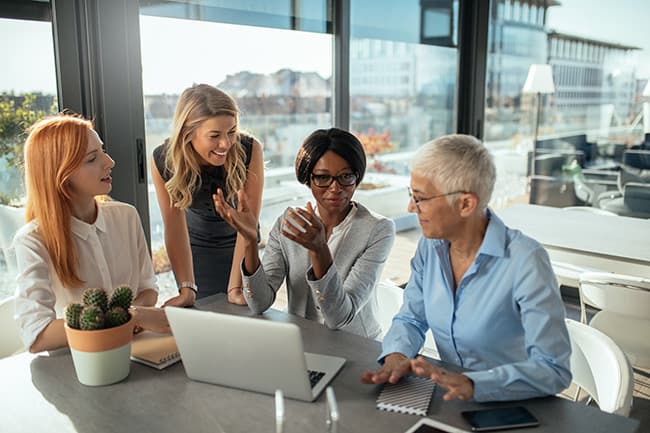 Four female business professionals sitting at a table